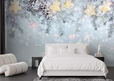 christmas tree branch under snow decorated with glowing star lights garland. frosty winter background Wall mural