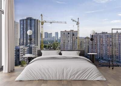 new residential buildings under construction. two tower cranes against blue sky background Wall mural