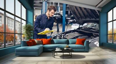 Auto car repair service center. Mechanic examining car engine Wall mural