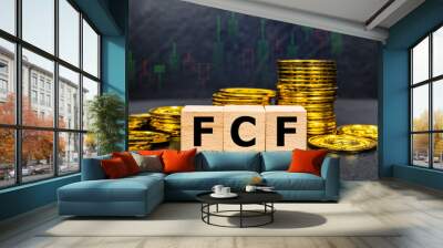 The inscription FCF text on wooden cubes with stack of coin on black background with stock market graph. Business profitability success growth profitability analytics. Business and financial concept. Wall mural