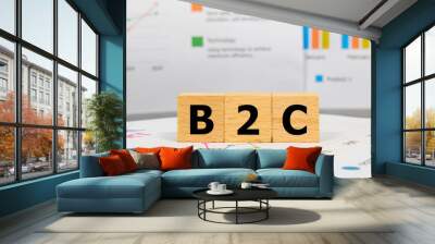 Three wooden blocks with the word B2C on a graph sheet. Abbreviation for Business to Consumer, growth business and investment. Business and financial market concept. Wall mural