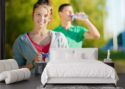 Man and woman drinking from bottle Wall mural