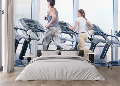 young woman and man at the gym exercising. running Wall mural