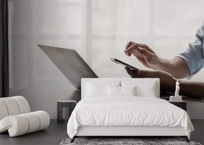 Mobile phone in the hand of a businessman holding a phone Email sending scam concept The work of an independent businessman. Close-up photo Wall mural