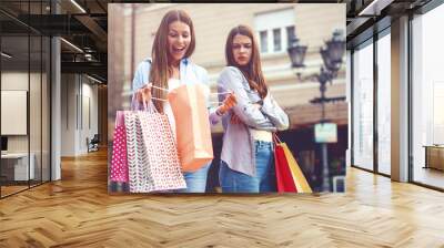 I want that! Two women after shopping. One of them is not satisfied Wall mural