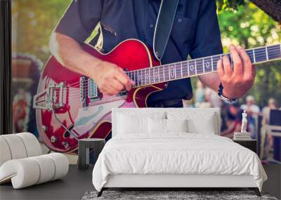 Man with a red electric guitar in the park playing a summer concert Wall mural