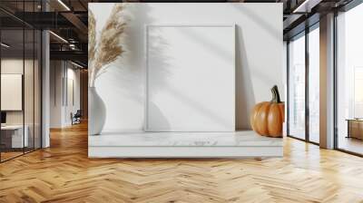 Minimalist fall decor with orange pumpkin and pampas grass on white console table, blank picture frame for mockups, templates. Perfect for autumn home decor, thanksgiving, design presentations
 Wall mural