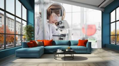 A young Asian woman scientist working in laboratory with test tube microscope and solutions. Wall mural