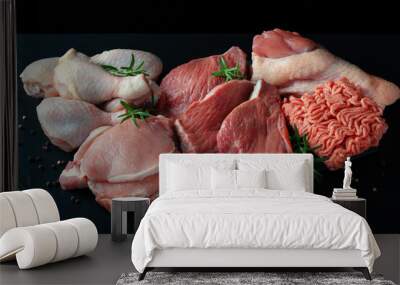 Various types of fresh meat: pork, beef, turkey and chicken on a black table Wall mural