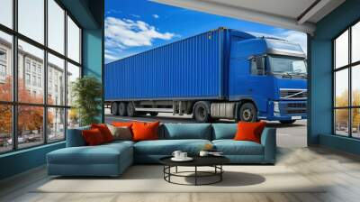 Large blue freight truck on a highway under a clear sky in daylight Wall mural