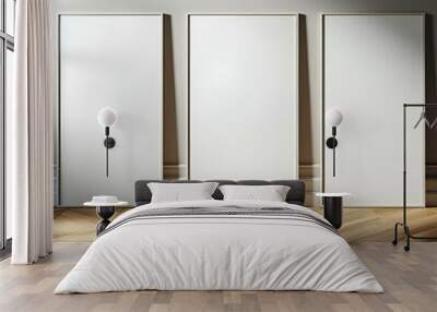 A modern, vacant room with parquet flooring has three vertical white blank wooden framed wall art mockups hanging against the wall. Shadows cast by realistic lighting on a blank canvas Wall mural