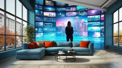 A person watching a video wall with multimedia images on different television screens.  Wall mural