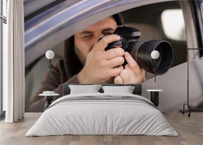 Male driver photographing with slr camera from car, Private detective taking photos Wall mural