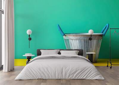 Empty metal basket with blue handles placed on yellow table against green wall with generative ai Wall mural