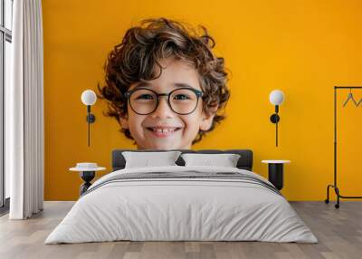 Cheerful young boy wearing glasses and beaming with happiness Wall mural