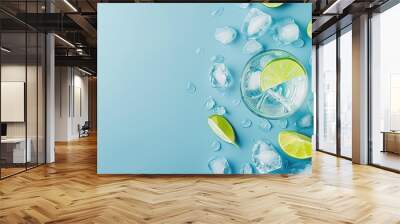 Gin and Tonic with lime wedge and ice block on top of blue background with copyspace for text Wall mural