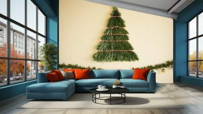 A DIY Christmas tree crafted from hanging green tinsel and garland, creating the silhouette of a tree on a wall. It is decorated with small colorful baubles and lights, perfect for limited spaces. Wall mural