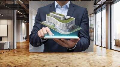 a man using a digital tablet with a hologram of a modern building. Wall mural