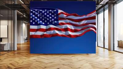 An artistic capture of the American flag, its fabric flowing dynamically in the wind against a deep blue sky, symbolizing freedom and pride. Wall mural