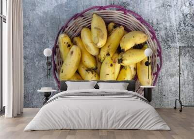 pile of small bananas on woven bamboo, isolated on the concrete floor Wall mural