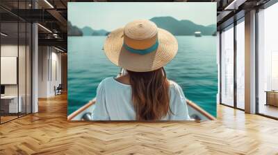 tourist woman wearing a hat sitting on a moving boat and enjoying the blue sea Wall mural