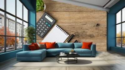 Calculator, notebook and a pen with a copy space on shabby wooden board background. Wall mural