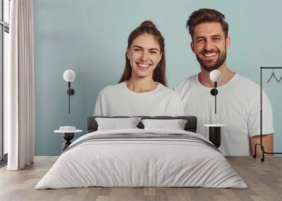 cheerful young couple in white t-shirts on a light background, logo Wall mural