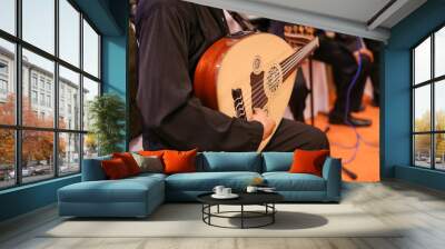 A man playing a Gambus on a wedding event, a musical instrument used for the famous Ghazal traditional song in the state of Johor. Wall mural