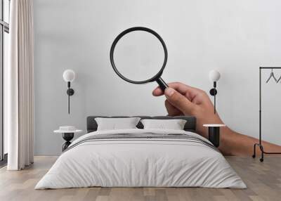 Hand holding Magnifying Glass isolated on white background Wall mural