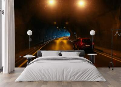 Road tunnel in mountain illuminated by lamps Wall mural