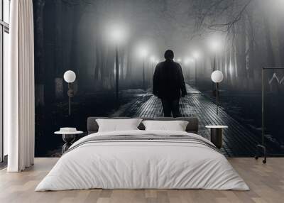 Sad man alone walking along the alley in night foggy park. Back view Wall mural