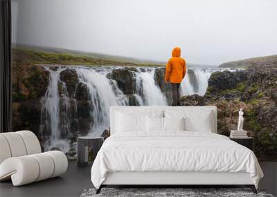 Male tourist standing and looking at Kolugljufur Canyon rapids flowing in Vididalur gorge at Iceland Wall mural