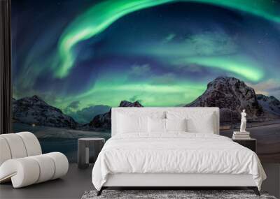 Northern lights explosion on snowy mountain range Wall mural