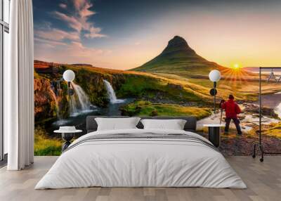 Sunrise over volcanic Kirkjufell mountain and photographer man standing in summer at Icelandnaefellsnes peninsula, Iceland Wall mural