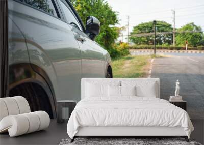 White modern SUV car with stain asphalt parked on roadside Wall mural