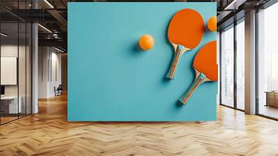 Two table tennis or ping pong paddles or rackets with table tennis ball on blue table background flat lay top view from above with copy space Wall mural