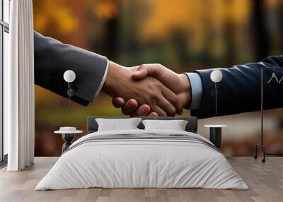 Close-up of business people shaking hands on blurred background of autumn park Wall mural