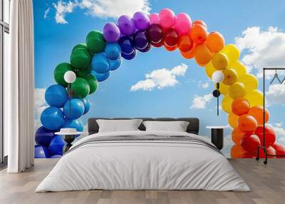 A colorful balloon arch in a blue sky, symbolizing celebration and joy. Wall mural