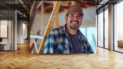 Portrait of happy Hispanic man working on new housing project. Professional latino worker using ladder and smiling at camera Wall mural