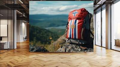 A backpack with a flag design rests on a rock in a scenic landscape. Wall mural