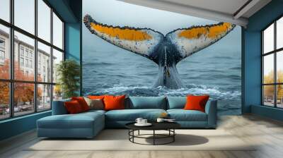 A whale's tail emerging from ocean waters in a misty atmosphere. Wall mural