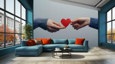 Two hands exchanging a red heart symbolizing love and connection. Wall mural