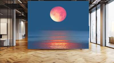 Lunar eclipse with calm sea at sunset 