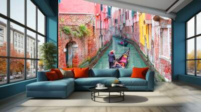 Venetian gondolier punting gondola through green canal waters of Venice Italy Wall mural