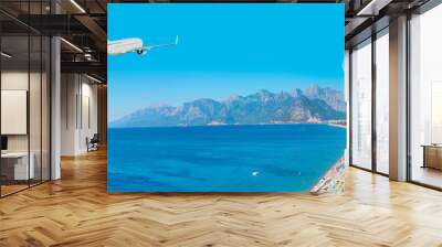 White an air plane fly over the konyaalti beach and blue sea - Antalya, Turkey Wall mural