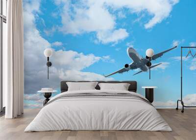 White passenger airplane flying in the sky amazing clouds in the background - Travel by air transport Wall mural