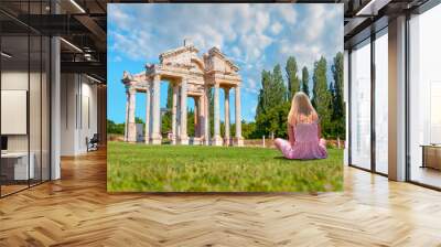 Young blonde girl sitting on the grass -    Famous Tetrapylon Gate in Aphrodisias -  Aydin , Turkey Wall mural