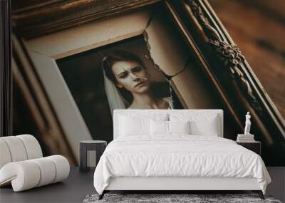 A cracked picture frame with a bride inside. Wall mural