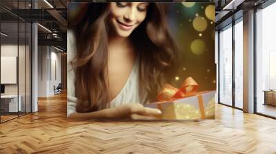 Beautiful young woman receiving and opening a nice gift with ribbon and bow, happy and wondering what is inside the box, a delighted girl smiling in the night, magic golden and red lights background  Wall mural