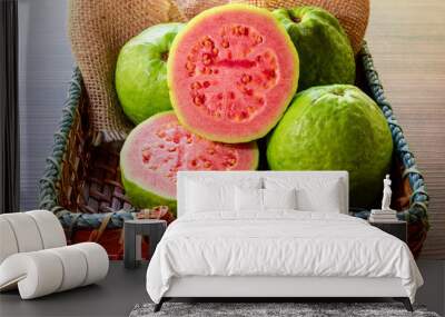 Closeup on red guava sliced with green leaf on rustic wooden background Wall mural